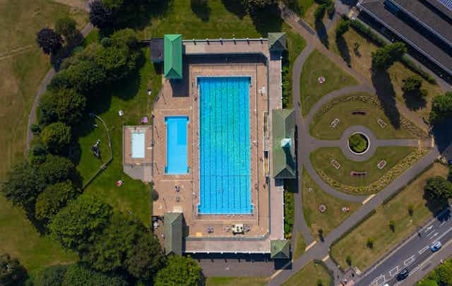 Peterborough's Vivacity Lido in an aerial shot showing its blue water and surrounding greenery.