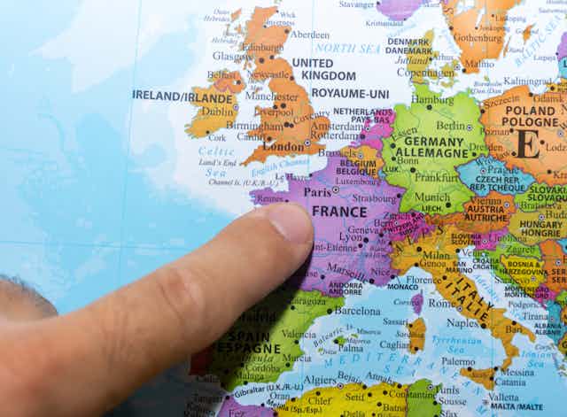 Une personne montre la France sur une carte d'Europe