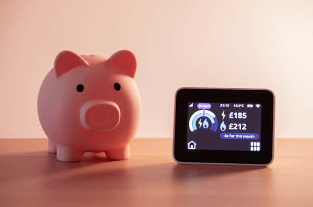 Piggy bank beside digital energy meter.