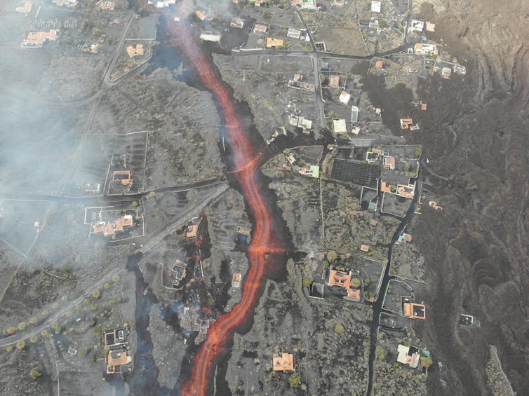 Aerial photo of houses with a river of lava flowing in between