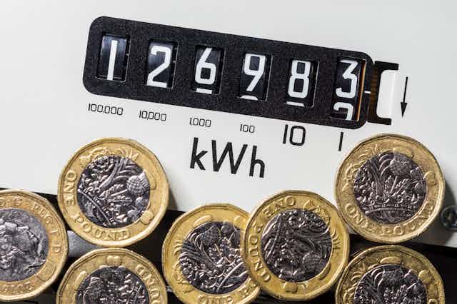 An electricity meter with pound coins on top.