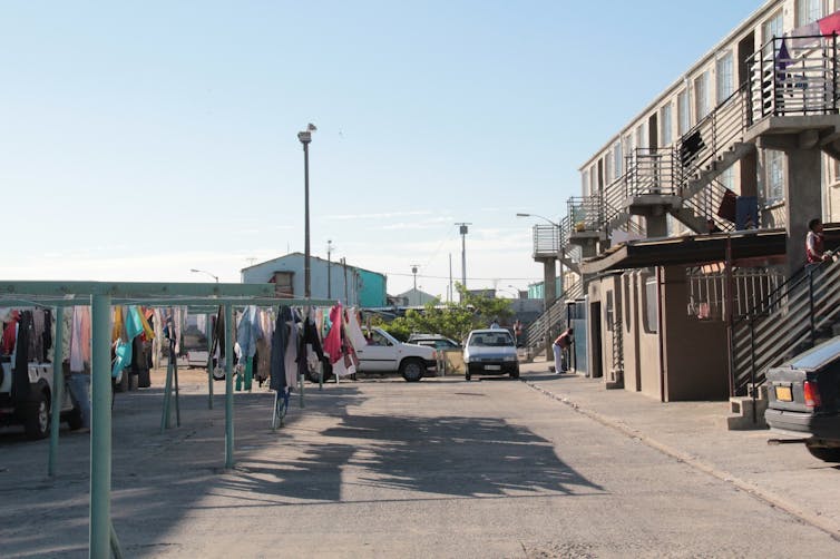 A block of apartments and a parking lot in a modest area.