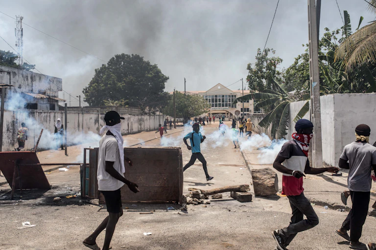 Des gens courent dans une rue de Ziguinchor barrée par des barricades improvisées