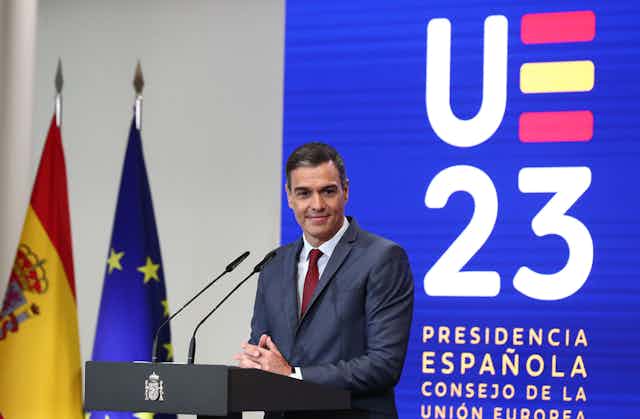 Pedro Sánchez en un atril con un panel de la Presidencia española de la Unión Europea de fondo.