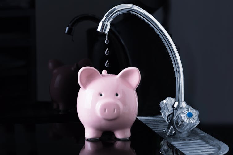 Water tap filling piggy bank.