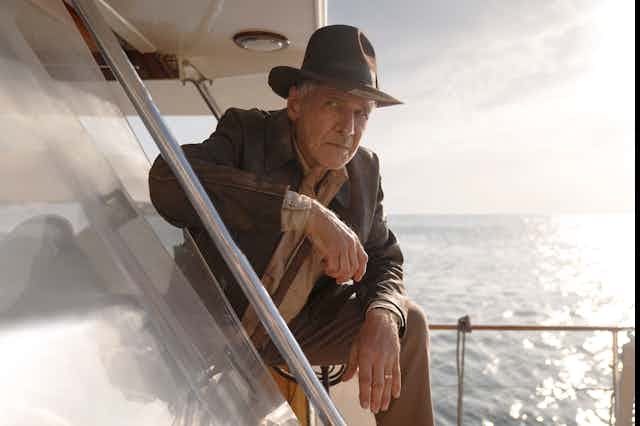  Harrison Ford leans on a boat, in a scene from Indiana Jones and the Dial of Destiny