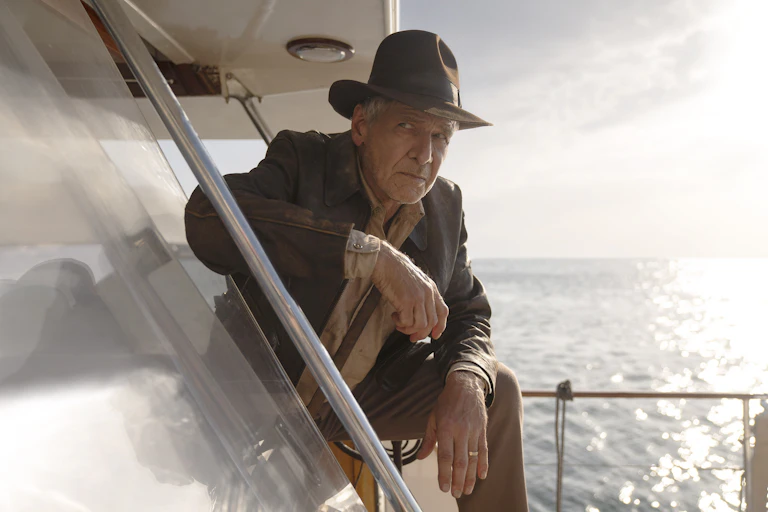 Harrison Ford leans on a boat, in a scene from Indiana Jones and the Dial of Destiny
