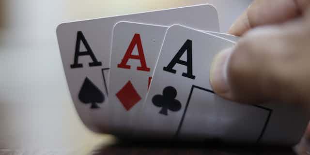 Card hand holding three Aces