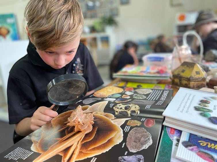 Do you know about the Australian school run by parents? 3 A student at Ngutu College looks at a book with a magnifying glass.