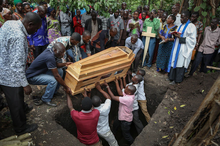 Men lowering a coffin into its burial space.