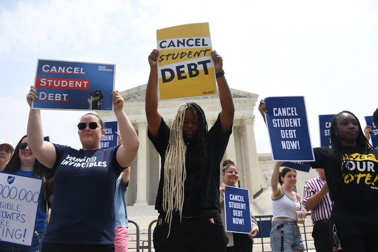 A group of protesters hold "cancel student debt" signs in Washington D.C.