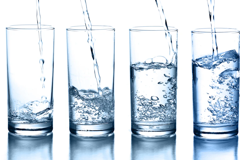 Water being poured into glasses to various levels..