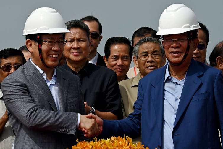 Two men in hard hats shake hands