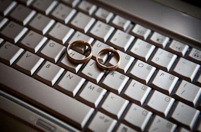 Two gold-colored rings of similar sizes sit on a computer keyboard.