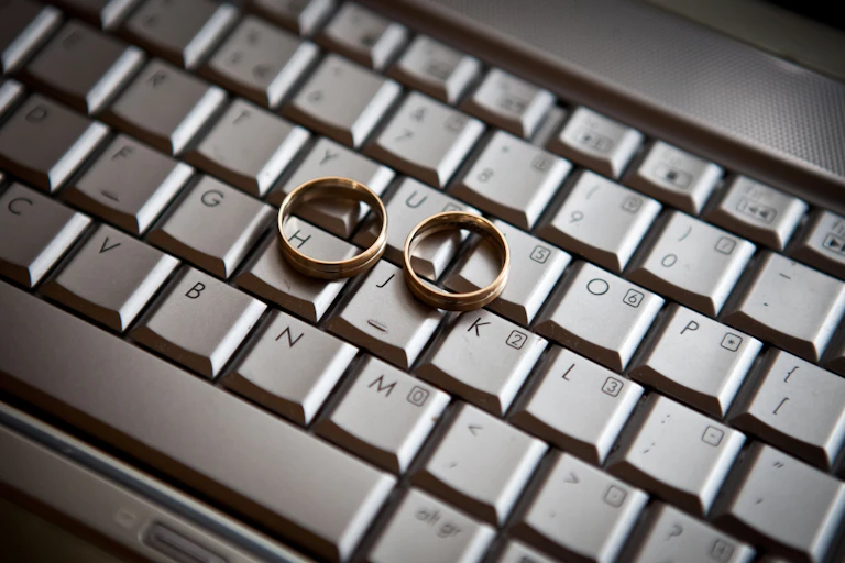 Two gold-colored rings of similar sizes sit on a computer keyboard.