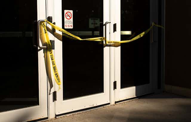 Yellow police tape across a door.