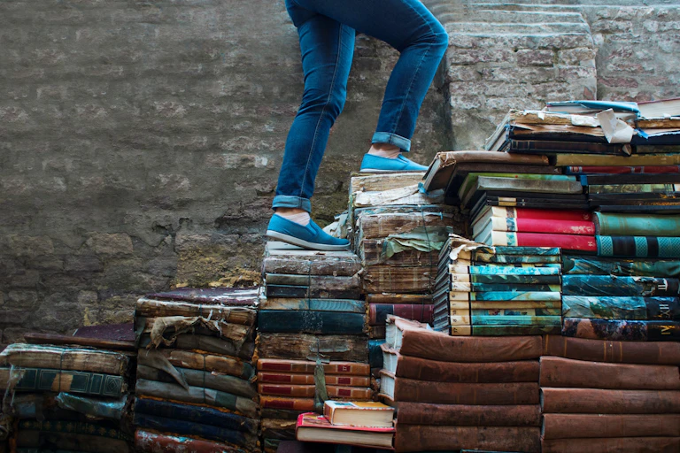 personne marchant sur des marches faites de livres
