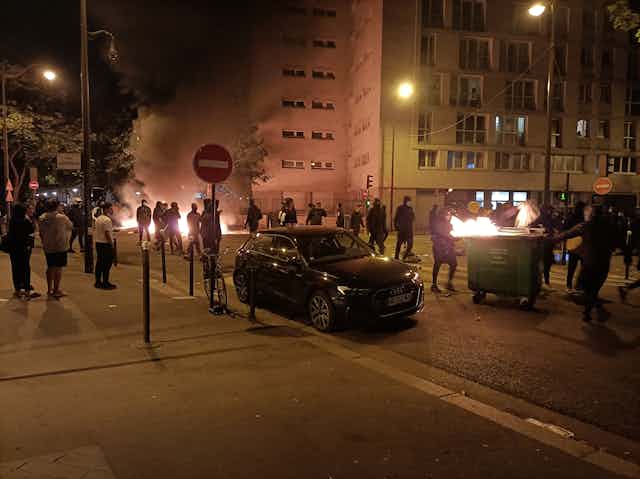 Des personnes brûlent des poubelles et bloquent une rue lors d'une manifestation à Paris le 29 juin 2023.