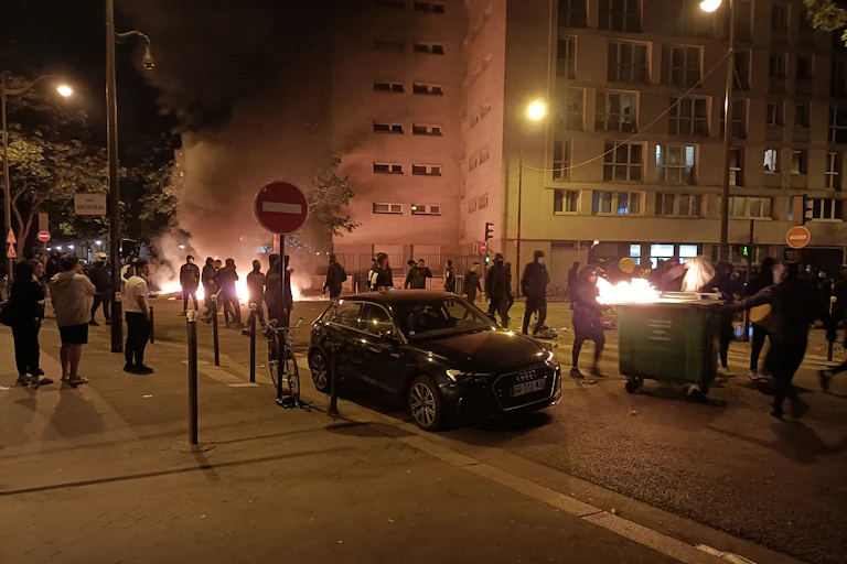 Des personnes brûlent des poubelles et bloquent une rue lors d'une manifestation à Paris le 29 juin 2023.