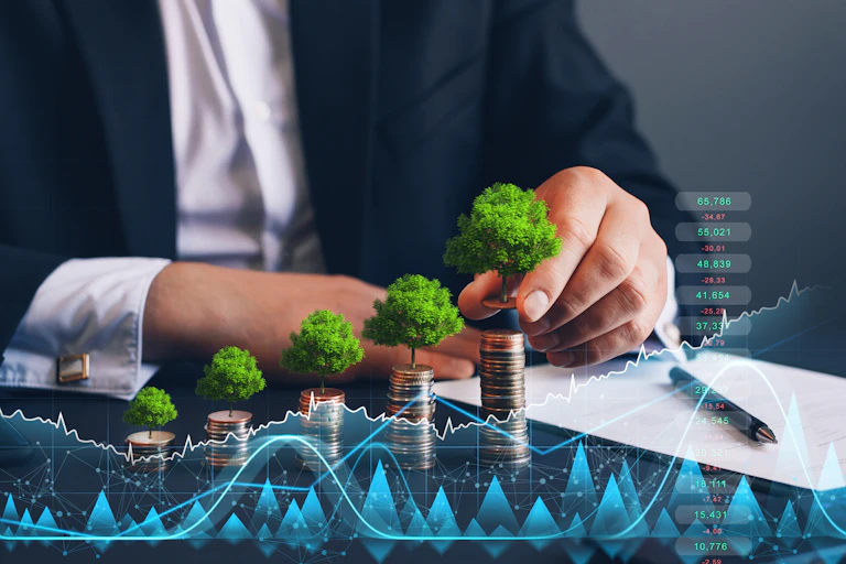 Person in suit holding coin with tree growing on coin stack and digital growth graph.