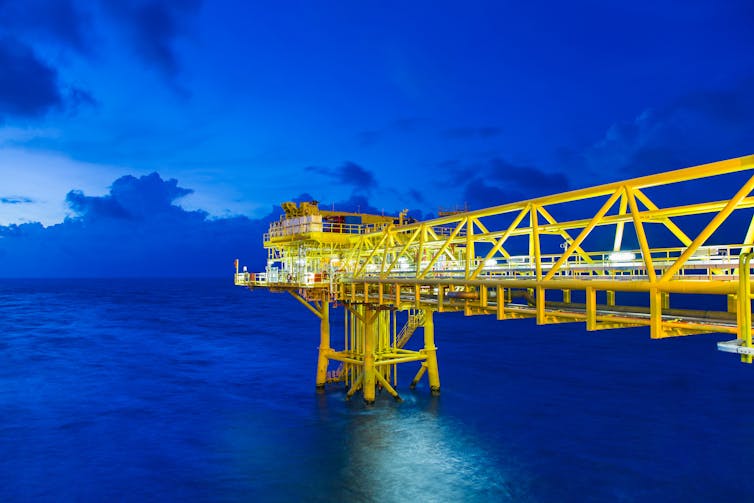 Offshore oil and gas wellhead, remote platform, sea in twilight.