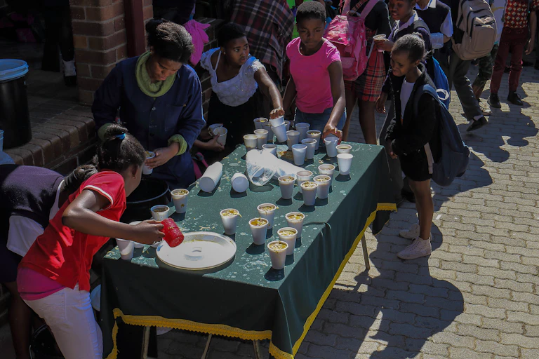 children waiting in line for a cup of soup
