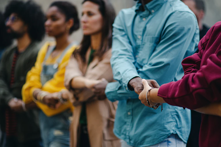 Group of people with arms linked, hands held.