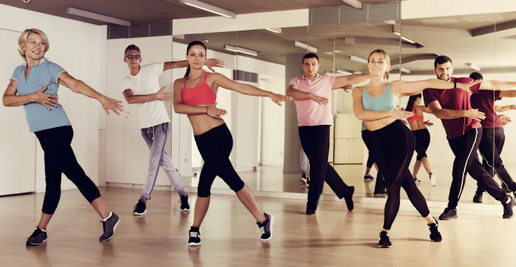 people in an exercise class mid-step