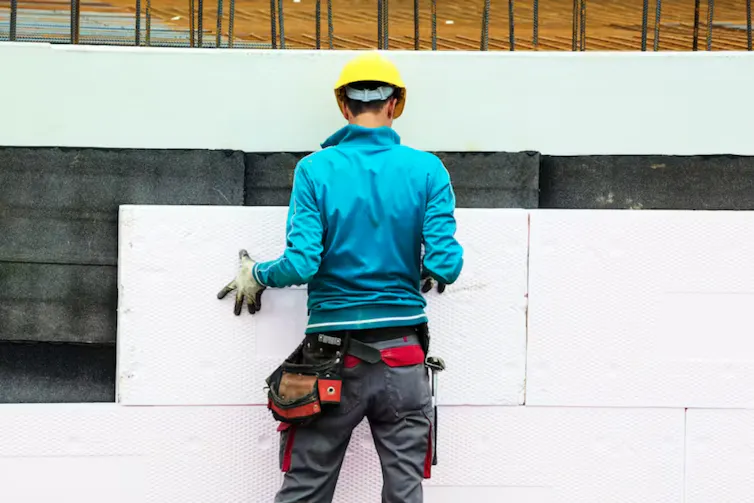 homme en train de fixer des panneaux d’isolation