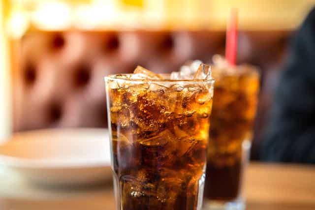 Two glasses of Coca-Cola or a similar soft drink.
