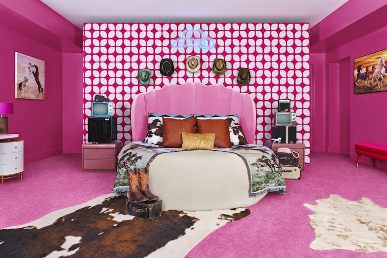 Dormitor roz cu pat rotund cu covor imprimat vaci.