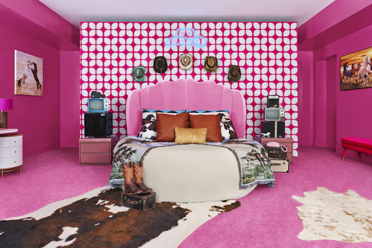 Pink bedroom including round bed with cow print rug.