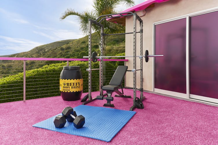 o stație de antrenament în casa roz Barbie Dreamhouse, cu saltea de yoga albastră.