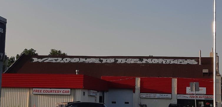 A building with graffiti on the roof, reading 