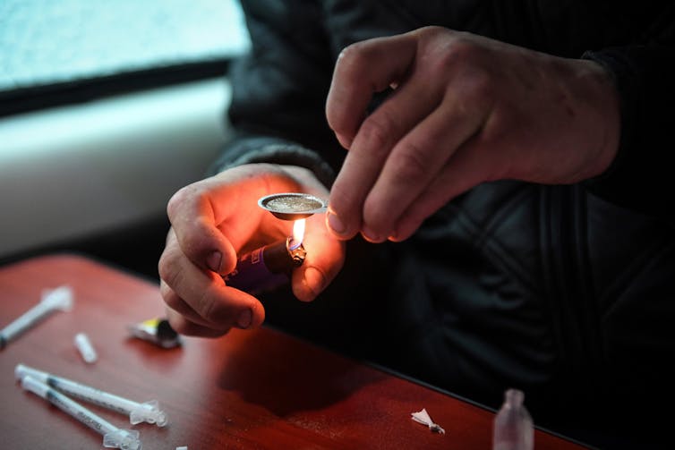 Un toxicomane prépare et s’injecte de l’héroïne