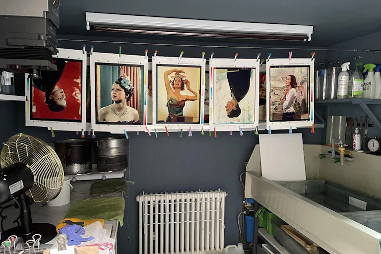 Yevonde prints hanging to dry in the studio of artist Katayoun Dowlatshahi. A fan and radiator are in shot.