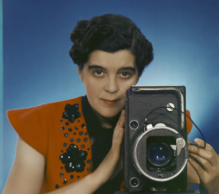 Yevonde holding a large camera.