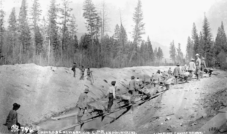 A black and white photo of men working on a railway line.