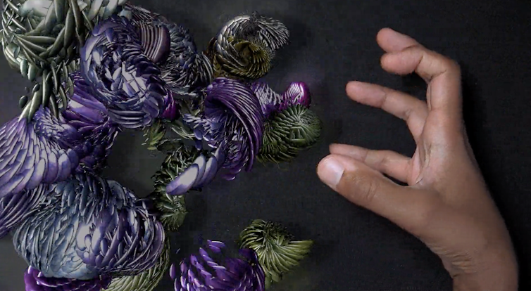 photo montrant une main humaine qui tente de saisir une image générée par ordinateur