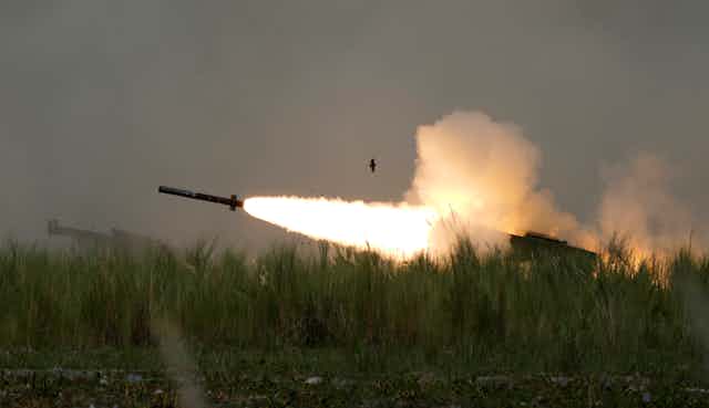 A missile with a plume of flame and smoke behind it.
