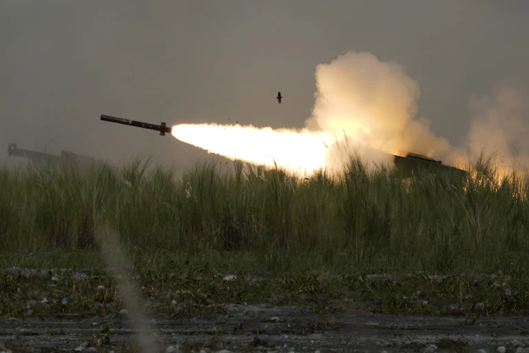 A missile with a plume of flame and smoke behind it.