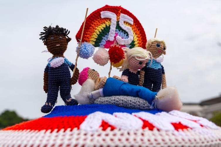 A crocheted postbox topper celebrating 75 years of the NHS