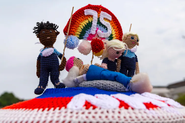 A crocheted postbox topper celebrating 75 years of the NHS