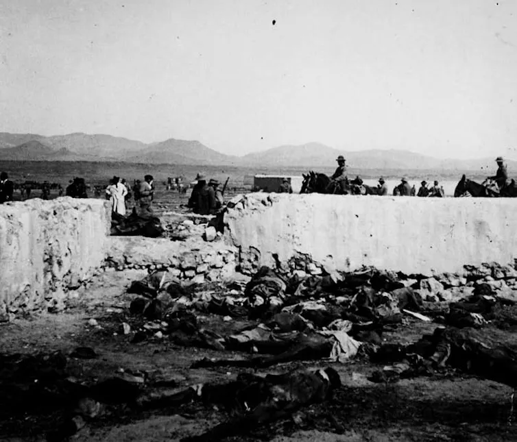 Fotografía de una llanura con cadáveres amontonados en el suelo.
