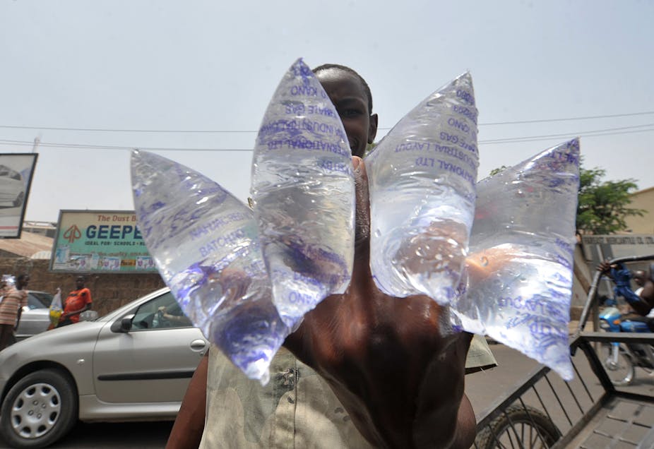 A boy sells water in a street of Kano, northern Nigeria