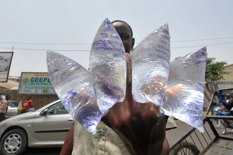 A boy sells water in a street of Kano, northern Nigeria