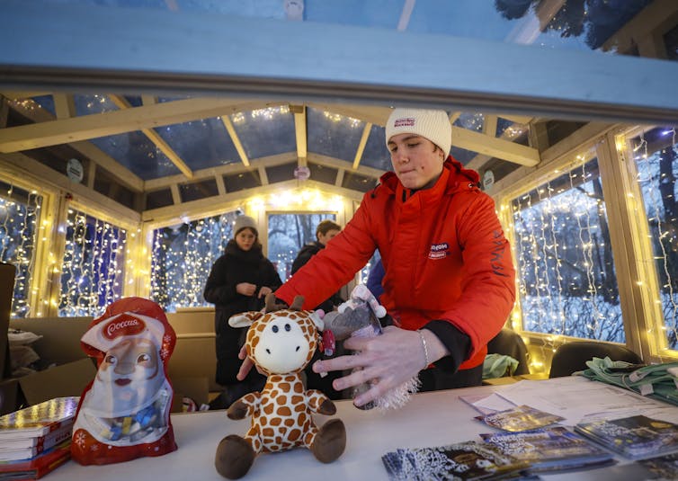 Women with stuffed toys at a charity stall on a Christmas market in Moscow, December 2022.