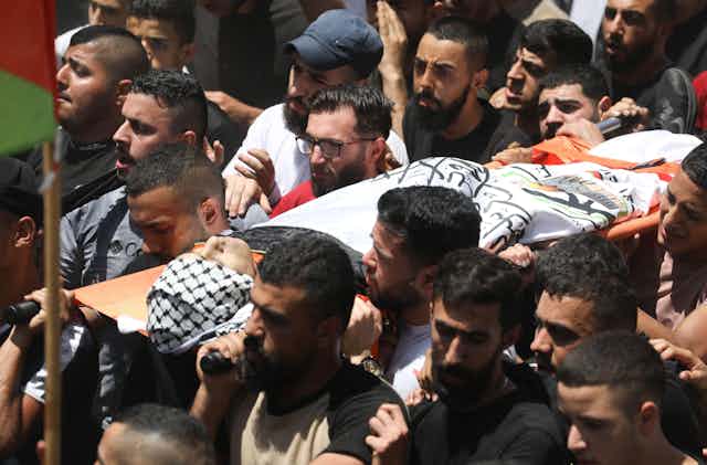 A group of Palestinian men carrying a coffin