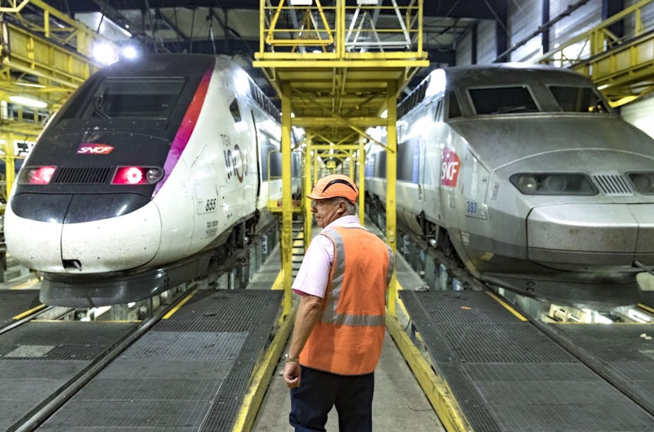 Personnel de maintenance devant deux rames de TGV