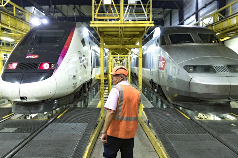 Personnel de maintenance devant deux rames de TGV